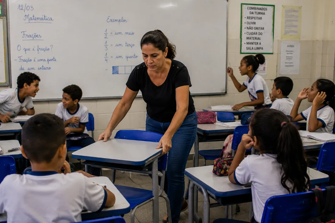 Professora reorganiza a disposição das carteiras enquanto os alunos se dispersam