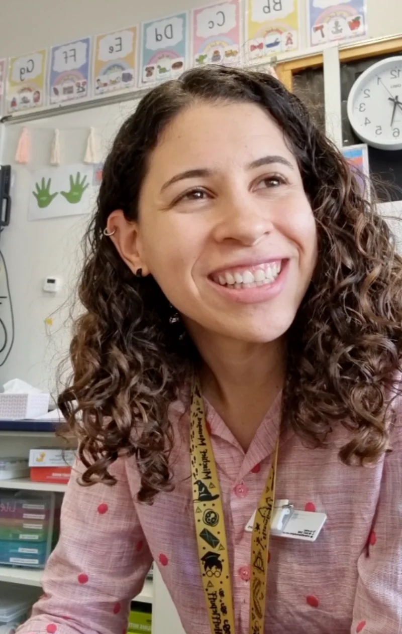 Hena Costa sorrindo em sua sala de aula